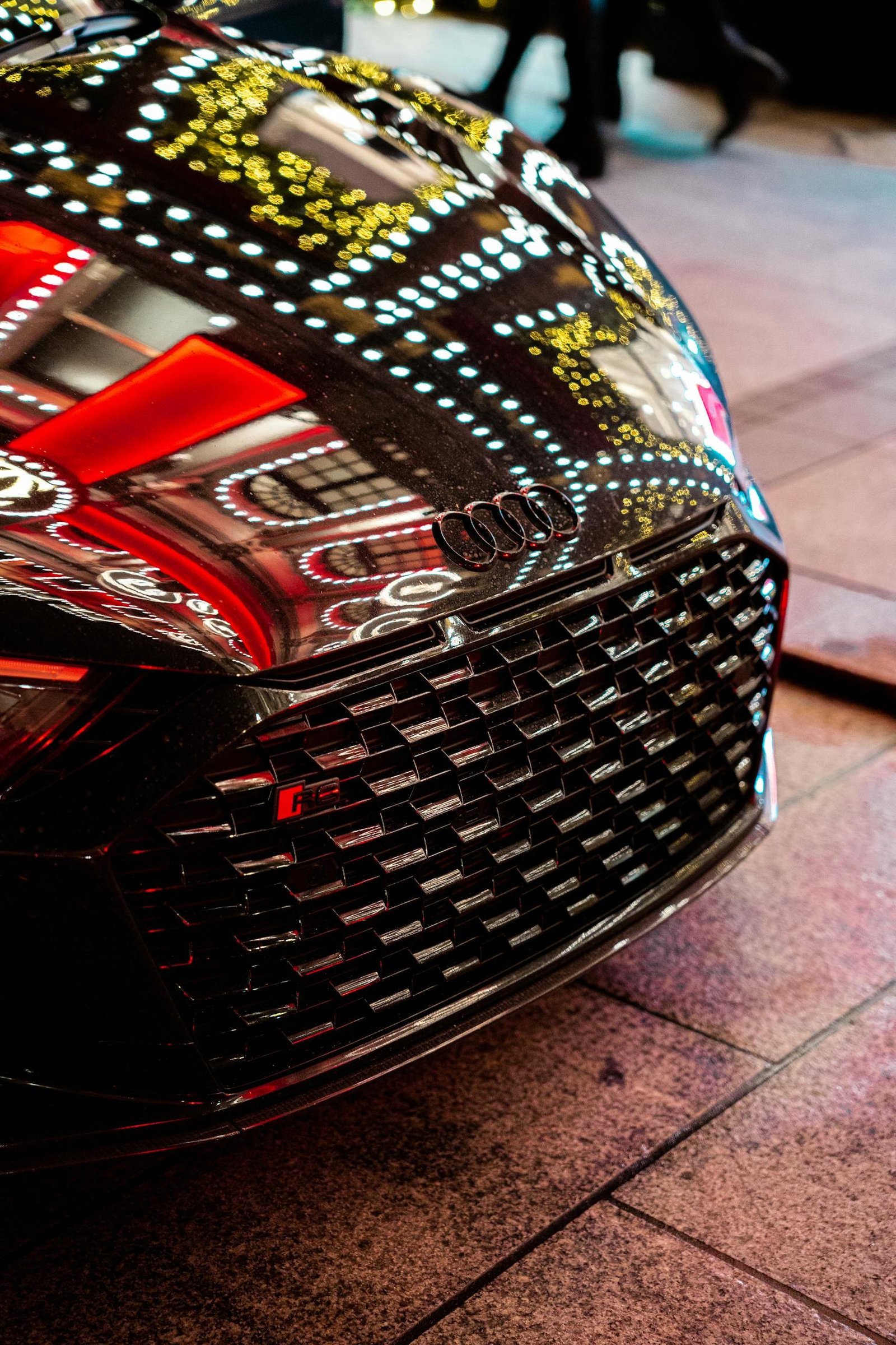 Close-up of a black Audi R8 with vivid reflections in London, capturing urban elegance and modern automotive design.