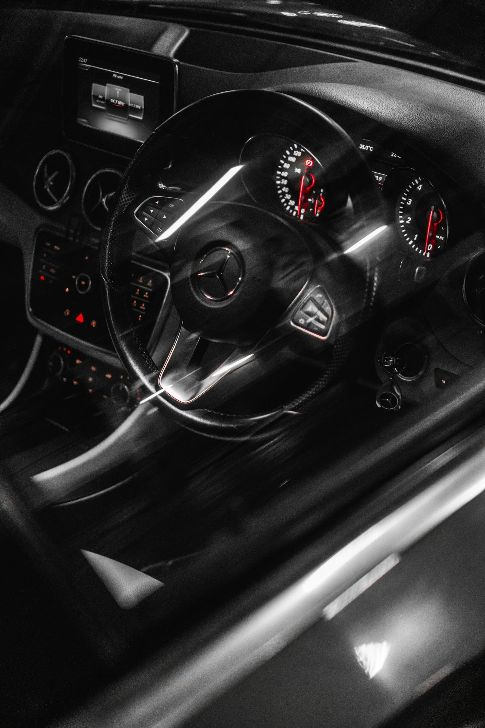 Close-up of a modern Mercedes-Benz car interior showcasing the dashboard and steering wheel in a luxury setting.