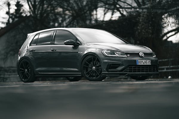 A sleek black Volkswagen Golf R parked on a road, showcasing its stylish design.