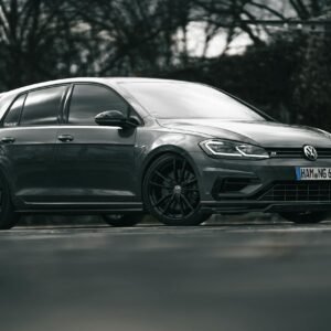 A sleek black Volkswagen Golf R parked on a road, showcasing its stylish design.