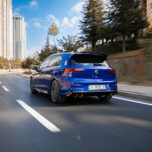 Blue sports car speeding on an urban street in Istanbul, Turkey, with city buildings in the background.