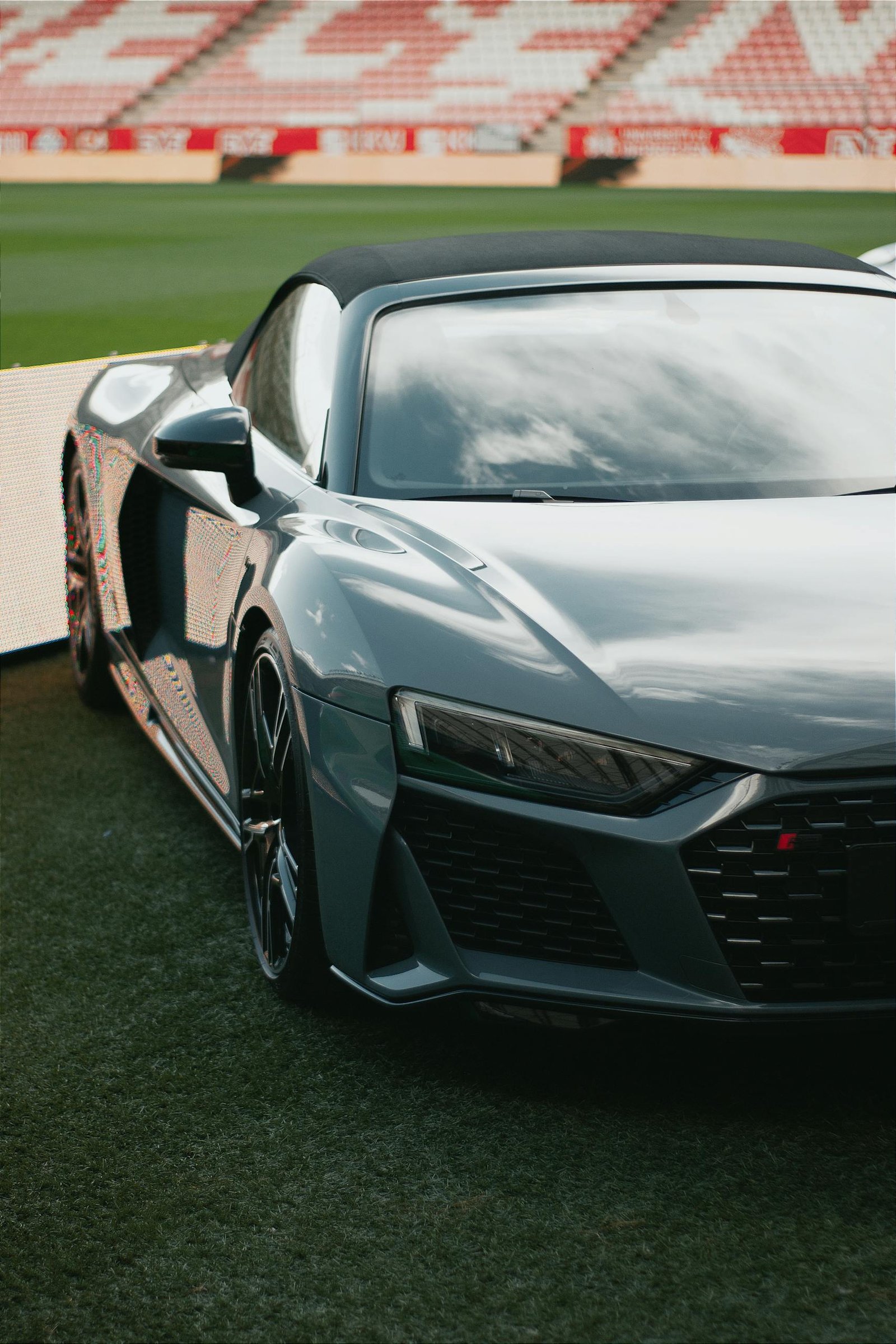 Close-up of a glossy Audi R8 parked inside a stadium in Hungary, showcasing modern automotive design.