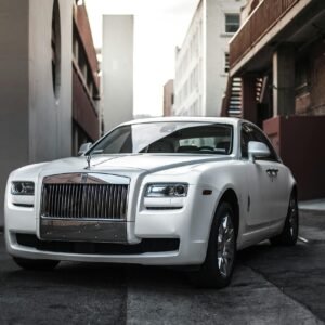 Elegant white luxury car parked in an urban alley, exuding sophistication and style.