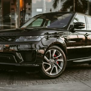 Sleek black SUV parked on a stone pavement, reflecting luxury and style.