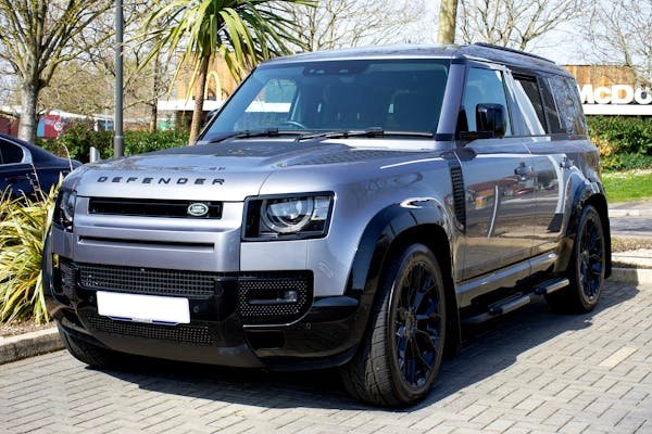 Sleek gray Land Rover Defender SUV parked outdoors in urban Christchurch, England.