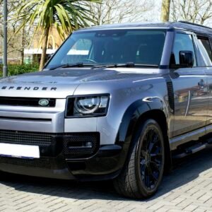 Sleek gray Land Rover Defender SUV parked outdoors in urban Christchurch, England.